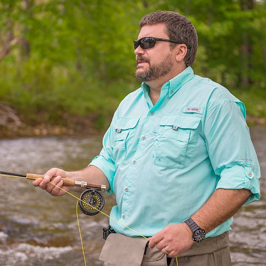 Man fly fishing wearing a blue Columbia Bahama ll shirt