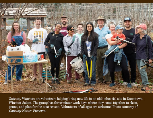 A group of volunteers standing outdoors in bare winter trees, holding gardening tools and standing next to a table with supplies. A large text banner overlays the bottom of the photo.