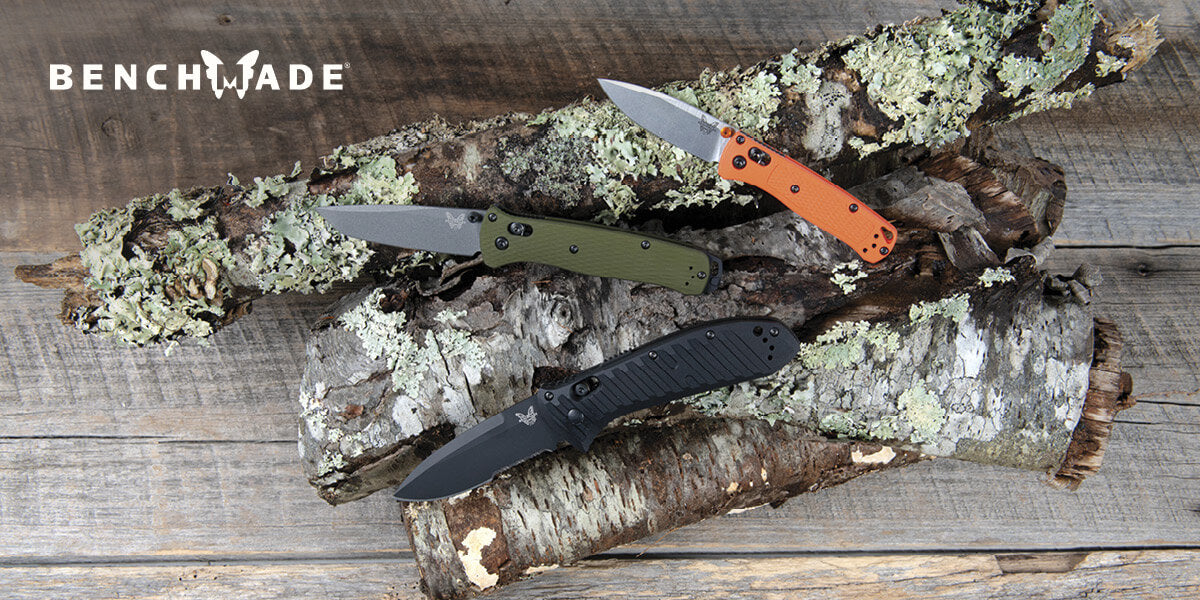 Three Benchmade knives on a wooden surface with lichen