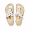 White floral slide sandals featuring a comfortable footbed and adjustable strap, perfect for warm weather wear.