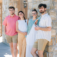 Four friends standing together on a sidewalk in relaxed spring and summer styles from Mast Store