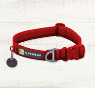 Red Ruffwear dog collar with logo on a light wooden background