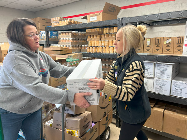 Rebekah and Addison help fill food boxes for the Hunger & Health Coalition